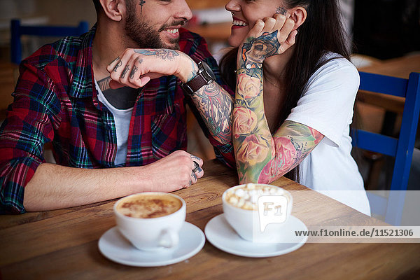 Paar im Café von Angesicht zu Angesicht lächelnd