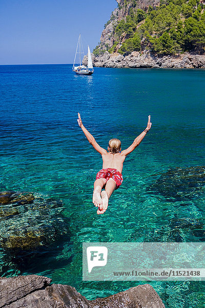 Rückansicht eines jungen Mannes,  der ins Meer taucht,  Cala Tuent,  Mallorca,  Spanien