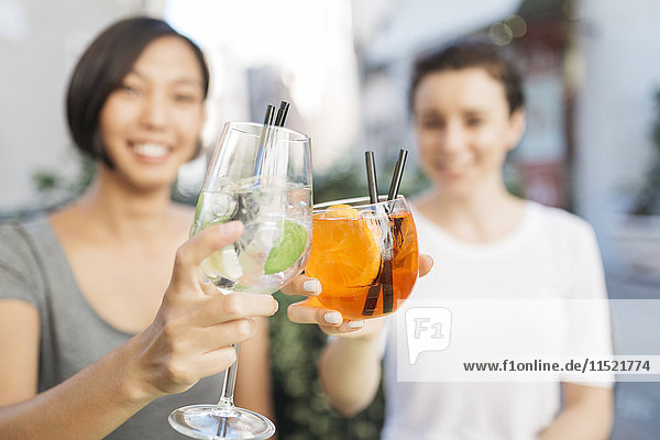 Two young women toasting with cocktails  close-up