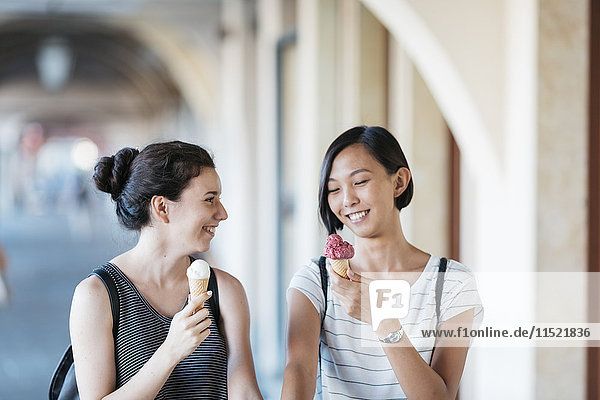 Zwei lächelnde junge Frauen mit Eistüten