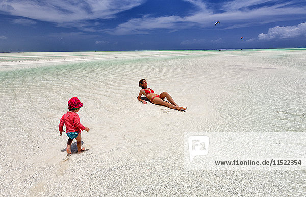 Tansania  Insel Sansibar  Paje  Mutter und kleine Tochter bei Ebbe am Strand entspannen