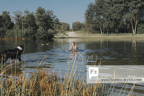 Netherlands  Schiermonnikoog  woman with Border Collie in a lake