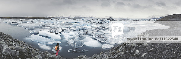 Island  Panoramablick auf Joekulsarlon  Gletscherlagune mit Mann im Vordergrund