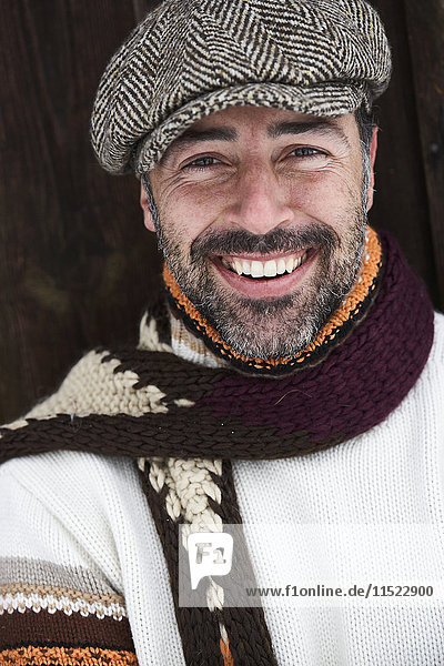 Porträt eines bärtigen Mannes mit Mütze und Schal im Winter