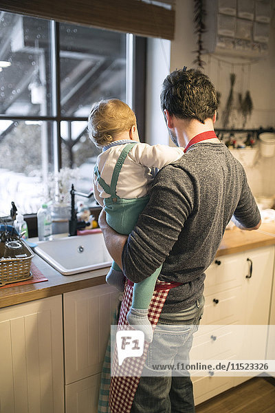 Vater und Junge in der Küche beim Geschirrspülen