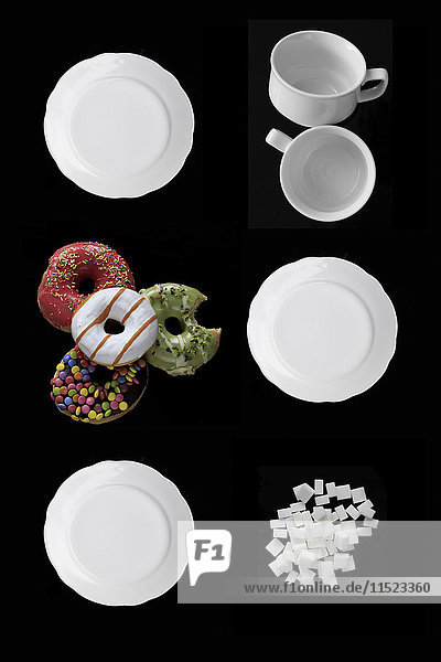 Weiße Gerichte  Donuts und Zuckerwürfel auf schwarzem Grund
