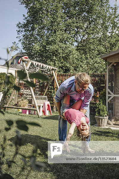 Vater spielt mit Tochter im Garten