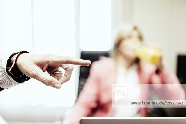 Hand of businesswoman pointing in office