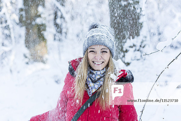 Porträt einer lächelnden jungen Frau bei starkem Schneefall