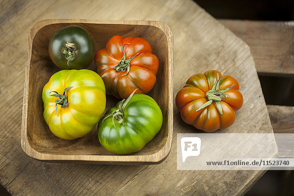 Wooden bowl of various Oxheart Tomatoes