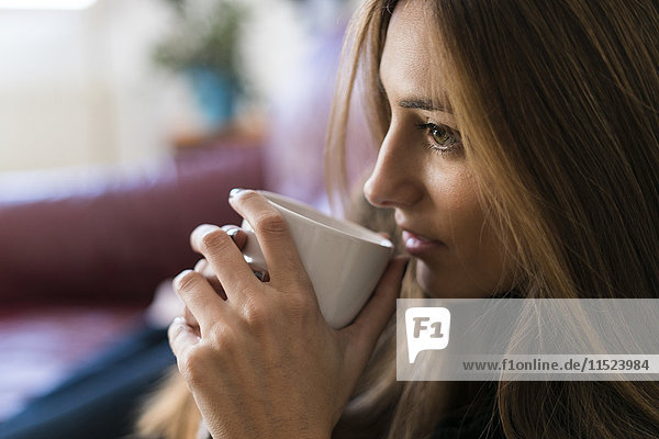 Junge Frau trinkt Kaffee aus der Tasse