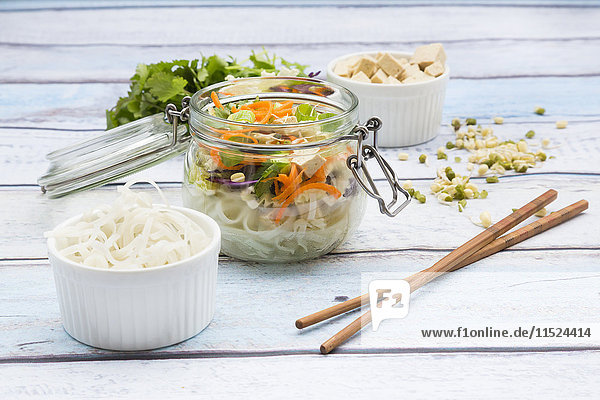 Asiatische Reisnudelsuppe mit Gemüse und Tofu im Glas