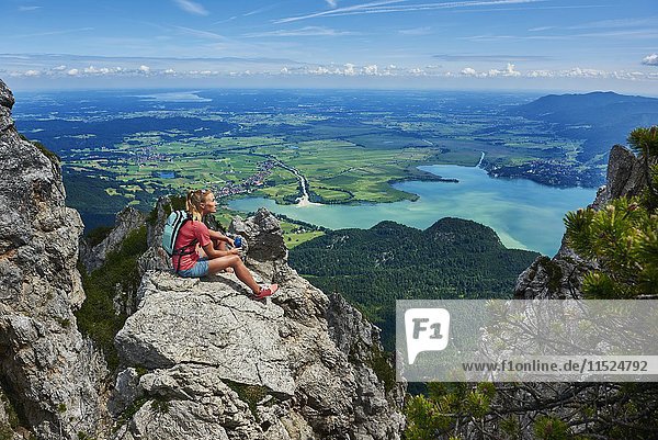Deutschland  Bayern  Junge Frau macht Pause nach dem Laufen in den Bergen