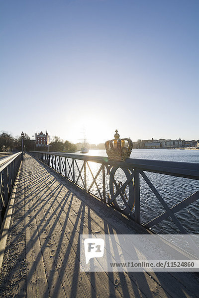 Schweden  Stockholm  Schwedische Königskrone am Geländer der Skeppsholmen Brücke bei Gegenlicht