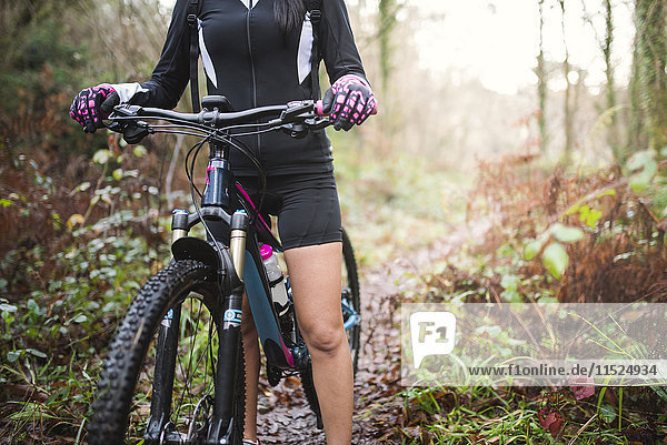 Female mountain biker on a trail in forest