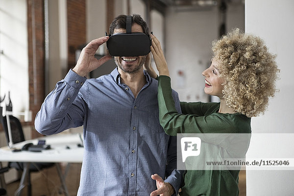 Happy woman and man with Virtual Reality Glasses in office