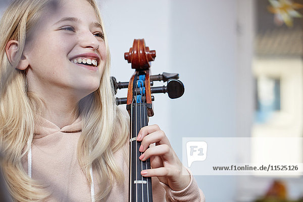 Porträt eines glücklichen Mädchens mit Cello