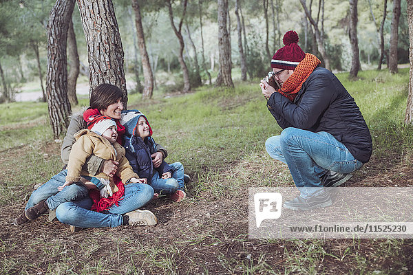 Vater fotografiert seine Familie im Wald