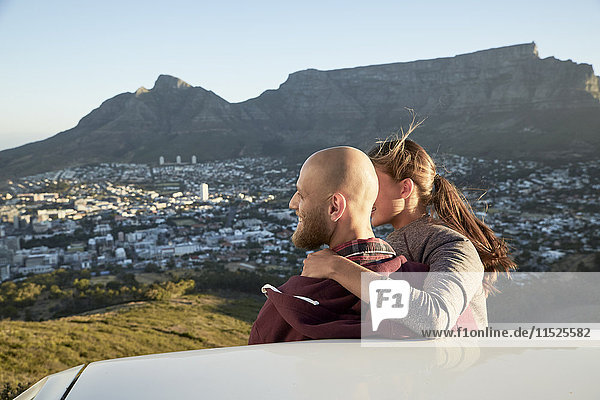 South Africa  Cape Town  young couple leaning against car looking at view