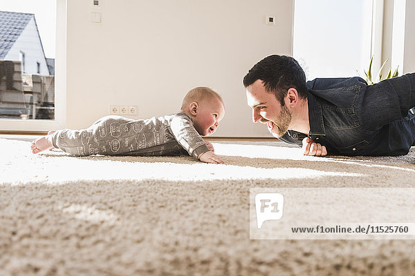 Vater und Sohn beim Krabbeln auf dem Teppich