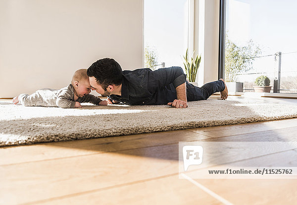 Vater und Sohn beim Krabbeln auf dem Teppich