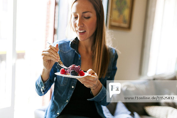Young woman eating a healthy dessert at home