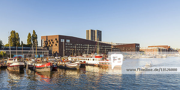 Niederlande  Amsterdam  KNSM Insel mit Piraeus Wohnhaus und Hausbooten im Vordergrund