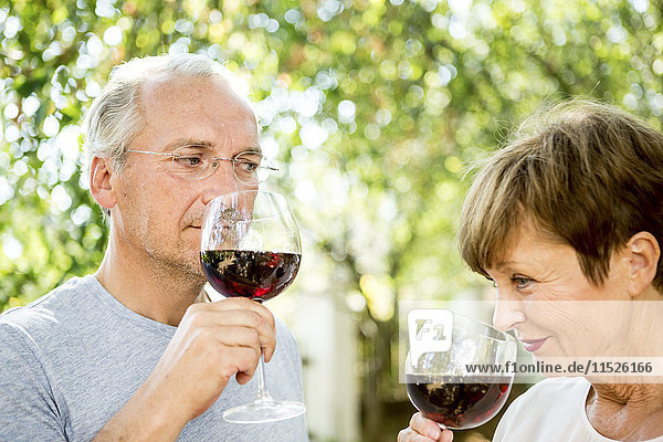 Seniorenpaar bei einem Glas Rotwein im Freien