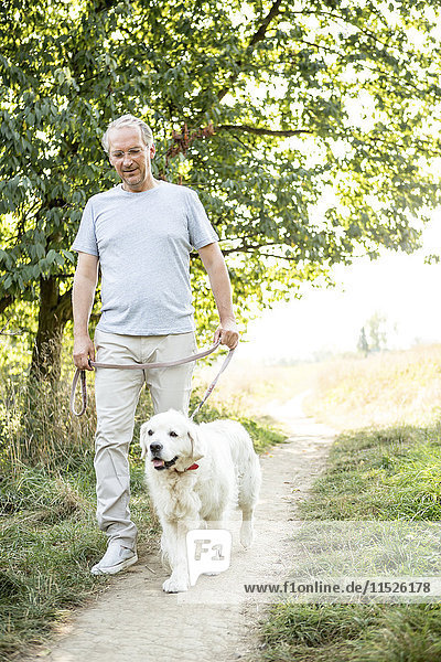 Älterer Mann geht mit Hund spazieren