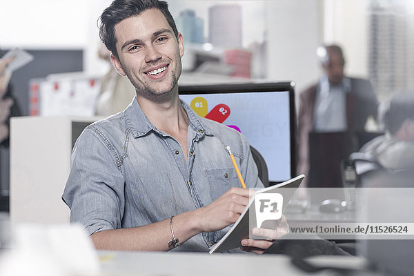 Portrait of smiling young man at office desk
