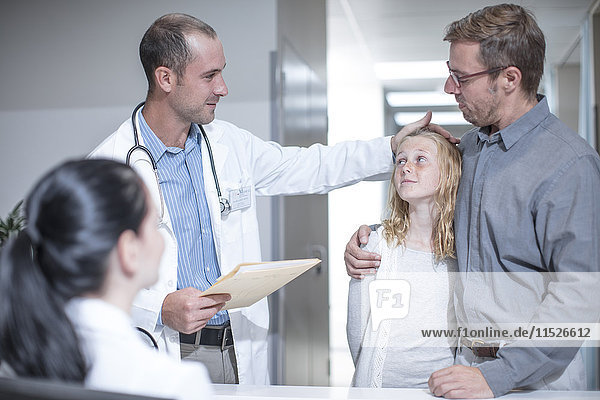 Arzt berührt Mädchen Stirn im Krankenhaus