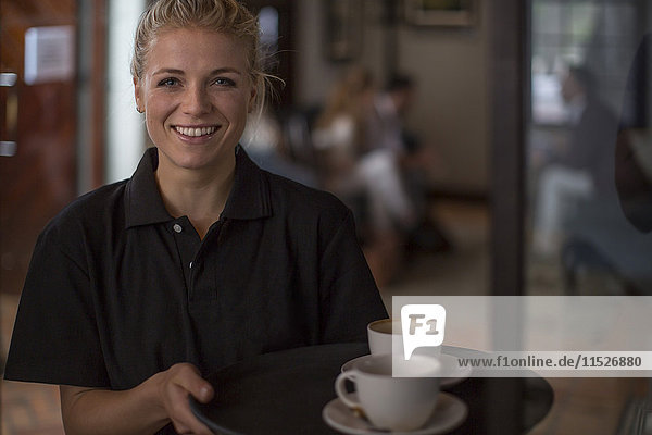 Porträt der lächelnden Kellnerin im Café