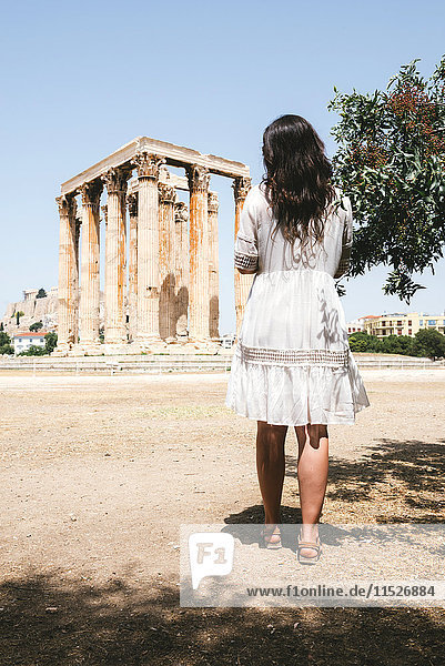 Griechenland  Athen  Frau beim Besuch des Olympion mit der Akropolis im Hintergrund