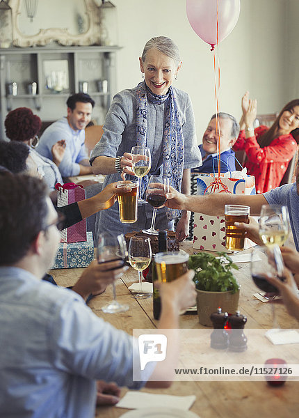Freunde toasten Wein und Biergläser bei der Geburtstagsparty im Restaurant