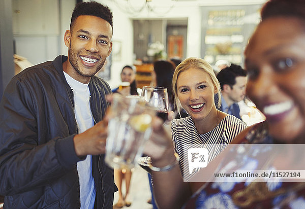 Portrait smiling man drinking with friends in bar