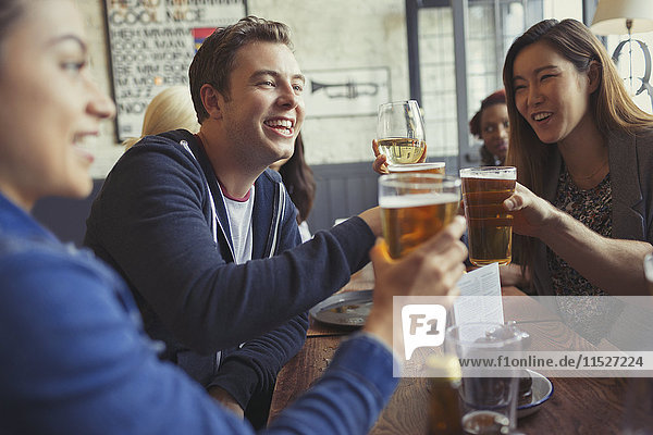 Freunde beim Feiern  Trinken von Bier und Weingläsern am Tisch in der Bar