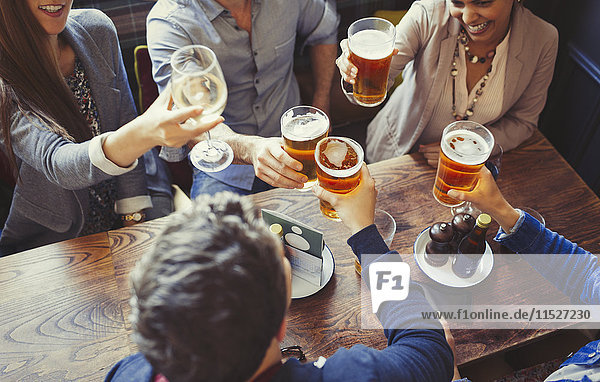 Freundeskreis beim Feiern  Trinken von Bier und Weingläsern am Tisch in der Bar
