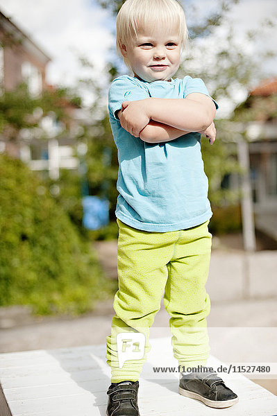 Little boy standing with arms crossed