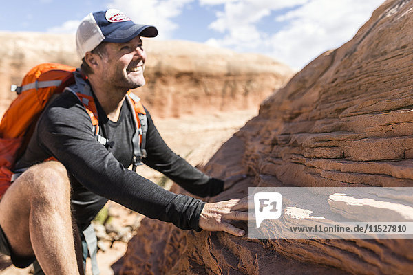 Smiling man climbing rock