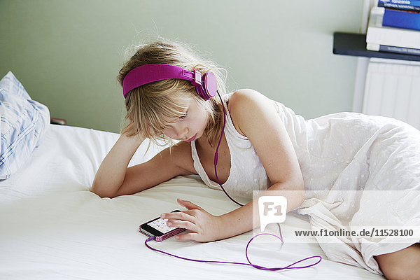 Girl with headphones using cell phone