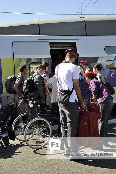 France  Western France  railway station of Nantes city  travelers boarding a high-speed train  SNCF employees helping disabled people carrying their luggage