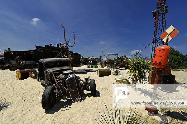 Frankreich  Wüstenlandschaft beim Hellfest. Altes Auto auf dem Sand  alter Strommast  Container auf dem Boden