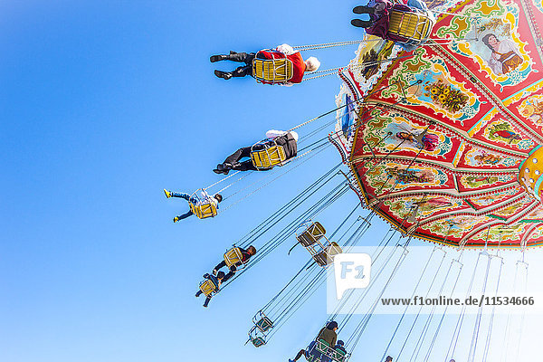 Germany  Munich  people enjoying ride on carousel during Oktoberfest