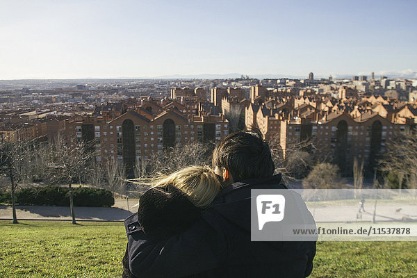Spanien  Madrid  Rückansicht eines verliebten jungen Paares auf einem Hügel mit Blick auf die Stadt