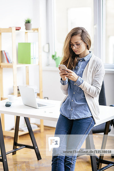 Young woman using smartphone in the office