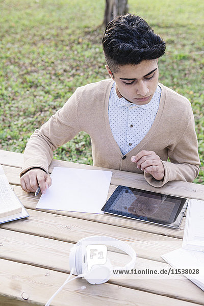 Student mit digitalem Tablettlernen im Park