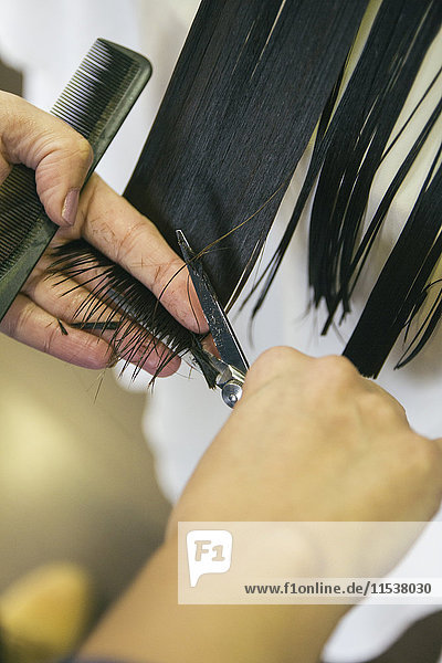 Friseur schneiden die Haare eines Mädchens in einem Friseursalon