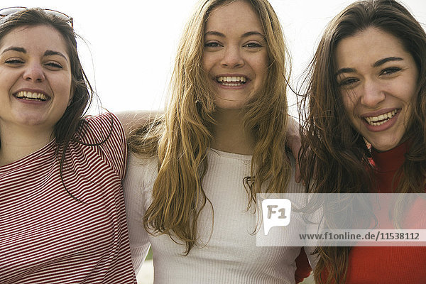 Porträt von drei glücklichen Frauen Arm in Arm
