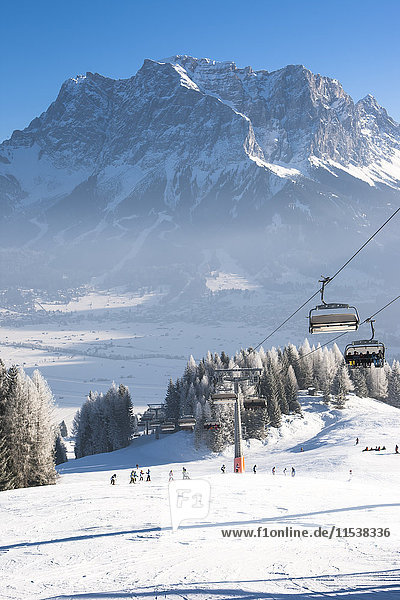 Österreich  Tirol  Lermoos  Sessellift in Winterlandschaft mit Blick auf die Zugspitze