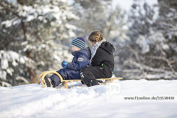 Two children sitting on a sledge